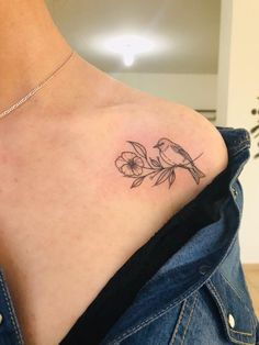 a small tattoo on the back of a woman's upper arm, with flowers growing out of it