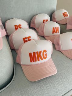 pink and white hats sitting on top of a gray couch