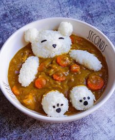 a white bowl filled with rice and some kind of bear face on top of it