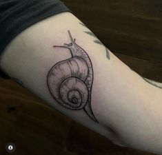 a small snail tattoo on the arm