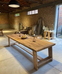 a large wooden table sitting inside of a warehouse