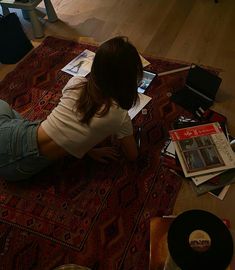 a woman sitting on the floor looking at her laptop