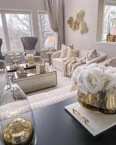 a living room filled with lots of furniture and flowers on top of a coffee table