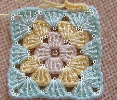 a close up of a square shaped ornament made out of crochet