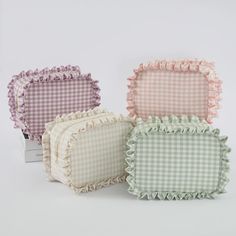 four pillows with ruffled edges in various colors