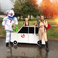 two people in costumes standing next to a car