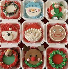 there are many decorated cupcakes in the box on the table with christmas decorations