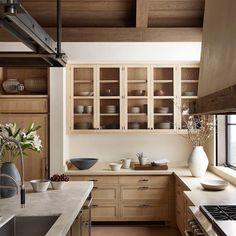 a kitchen filled with lots of wooden cabinets and counter top space next to a window