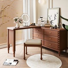 a desk with a mirror, stool and plant on it next to a window covered in blinds