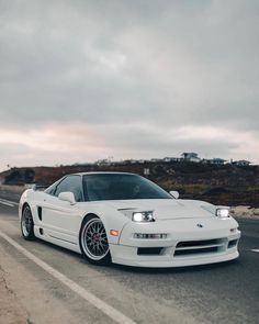 a white sports car driving down the road