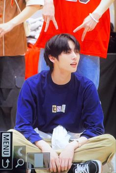 a young man sitting on top of a basketball court