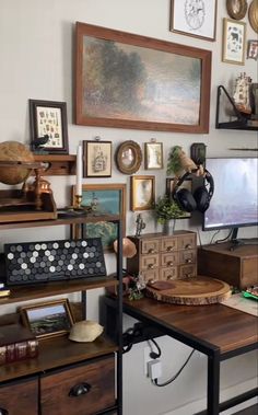 a living room filled with lots of furniture and pictures on the wall above it's desk