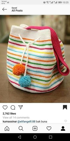 a multicolored striped purse sitting on top of a wooden table