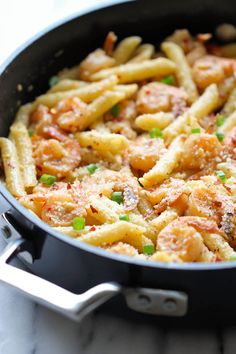 a skillet filled with pasta and meat