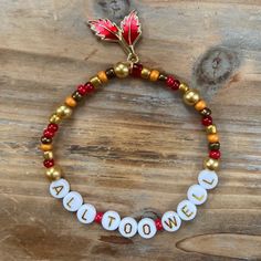a beaded bracelet with gold, white and red beads that says alotme