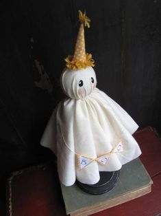 a stuffed animal wearing a white dress with a gold crown on it's head