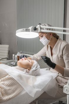 a woman is getting her face examined by a doctor