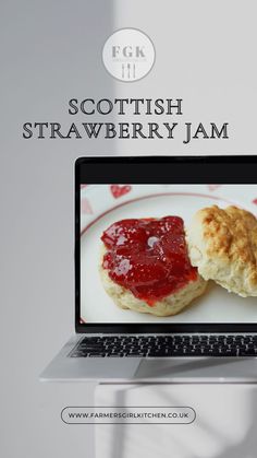 a laptop computer sitting on top of a white plate covered in jam next to a scone