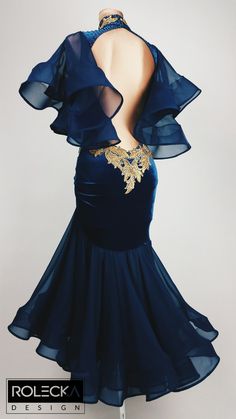 the back of a blue dress with gold details on it and an open neckline