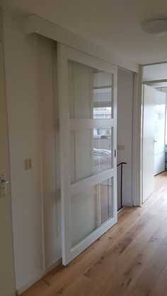 an empty room with sliding glass doors and hard wood flooring