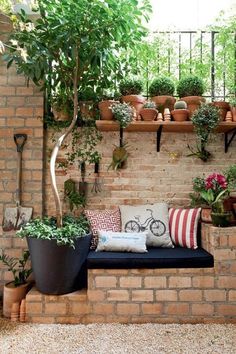 a brick wall with potted plants on it and a bench in the middle,