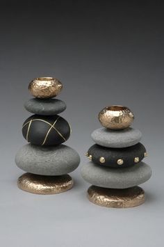 three rocks stacked on top of each other with gold accents and black stones in the middle