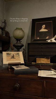 an old dresser with books and other items on it, including a framed portrait in the corner