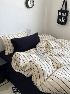 a black and white bed in a room with a clock on the wall