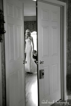 a woman in a wedding dress looking at herself in the mirror