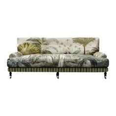 an upholstered couch with palm trees on the back and green trimmings