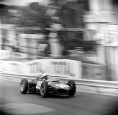 a black and white photo of a race car driving down the track with blurry background