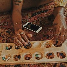 a woman sitting on the floor with her cell phone in front of an array of rings