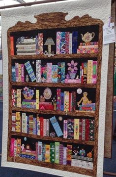 a quilted book shelf with many books on it