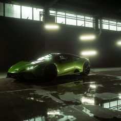 a green sports car parked in a parking lot with lights shining down on it's side