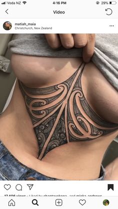 a woman's stomach with an intricate tattoo on it