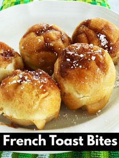 small pastries are on a white plate with sugar sprinkled on top, sitting on a green tablecloth