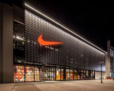 the outside of a nike store lit up at night