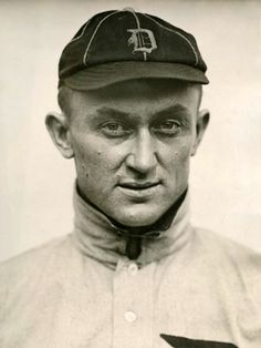 an old black and white photo of a man wearing a baseball cap with the letter d on it