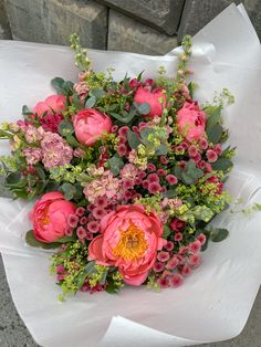 a bouquet of pink flowers sitting on top of a white paper