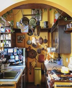 a kitchen with pots and pans hanging on the wall above the stove top oven