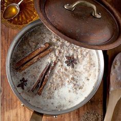 an overhead view of some food in a pot with spoons and bowls around it