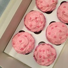 six cupcakes with pink frosting in a box