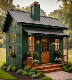 a small green house with a porch and steps leading up to the front door is shown