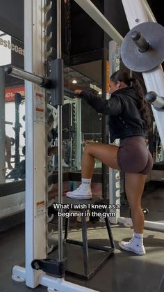 a woman squats on a bench in front of a gym machine with the caption links in bio