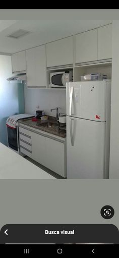 a kitchen with white cabinets and an appliance on the wall next to it