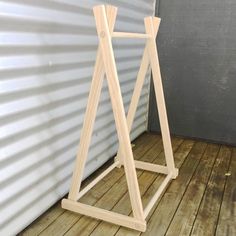 a wooden easel sitting on top of a hard wood floor next to a building