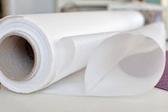 a roll of white paper sitting on top of a table next to a purple mat