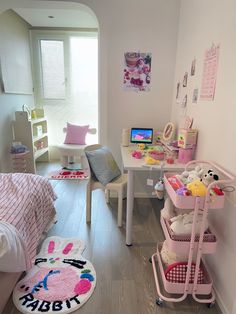 a child's bedroom with pink furniture and accessories