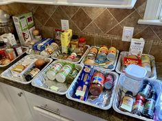 an organized kitchen counter with food items in containers on the top and below it,