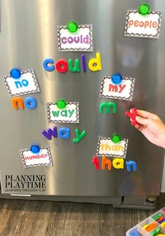 a child is playing with magnets on the refrigerator